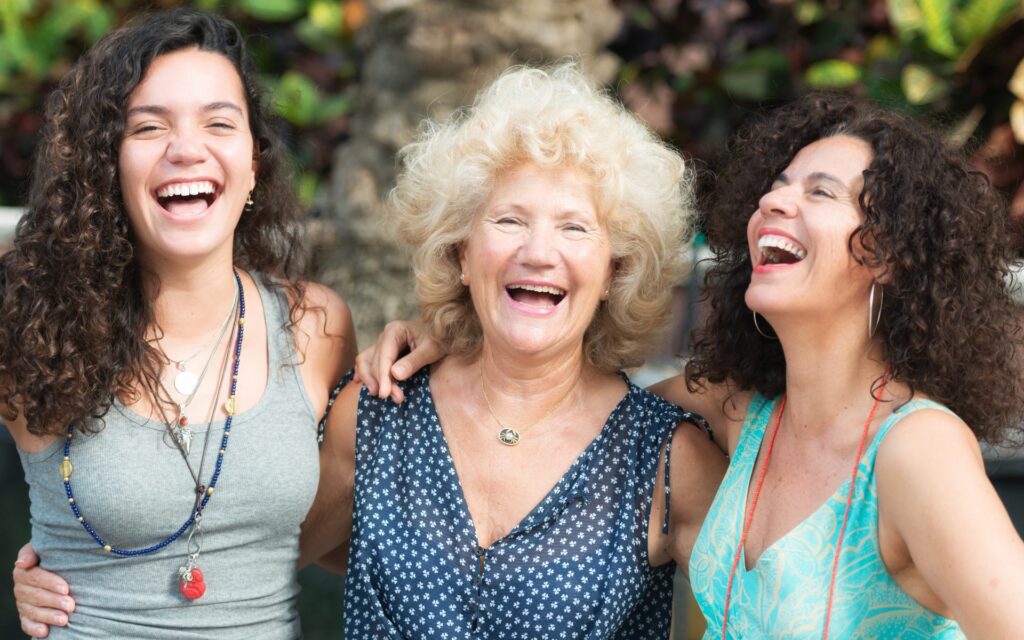 three generations of women laugh and smile for the camera