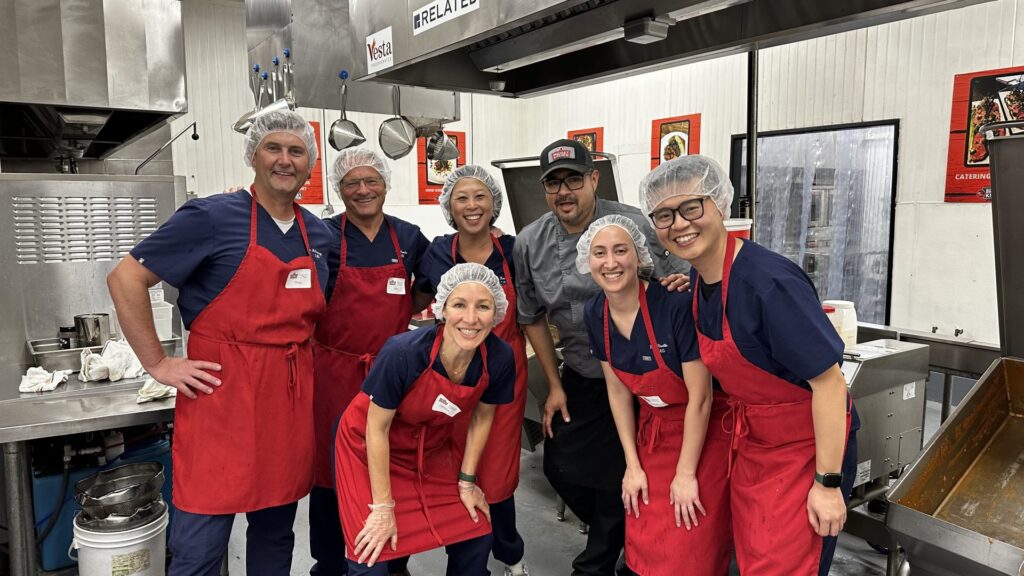 emg doctors and brackens kitchen staff pose together in red aprons